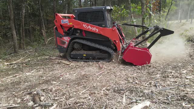 Side view of the drum mulcher running across a cleared lot in Lascassas, TN