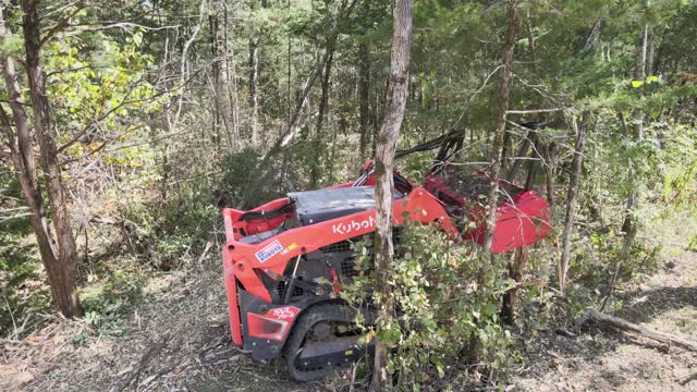 Drum mulcher pushing over a sapling on a wooded lot in Lascassas, TN